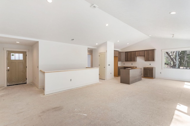 1826 S Barnes Rd, Muskegon, MI 49442 - unfurnished living room featuring plenty of natural light, lofted ceiling, light colored carpet, recessed lighting, and baseboards