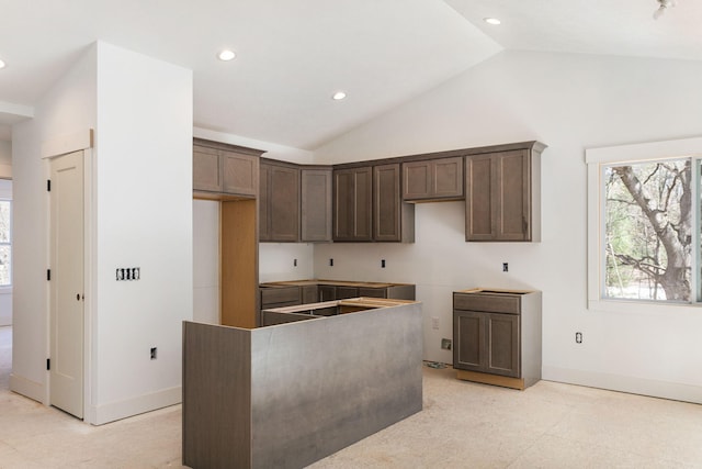1826 S Barnes Rd, Muskegon, MI 49442 - kitchen with lofted ceiling, a kitchen island, recessed lighting, dark brown cabinetry, and baseboards