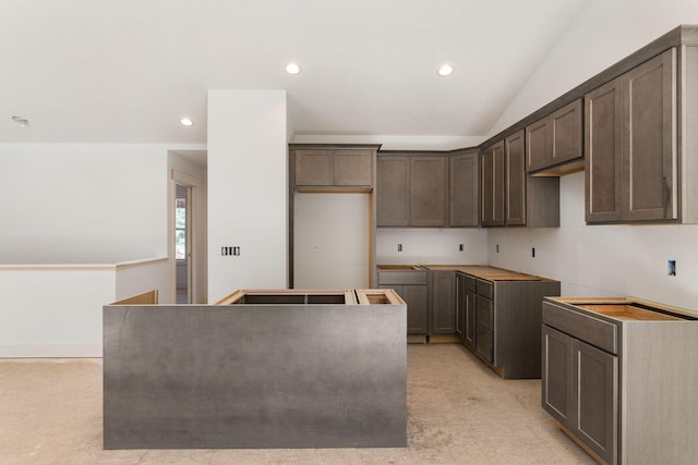 1826 S Barnes Rd, Muskegon, MI 49442 - kitchen with dark brown cabinetry, recessed lighting, a kitchen island, light colored carpet, and lofted ceiling
