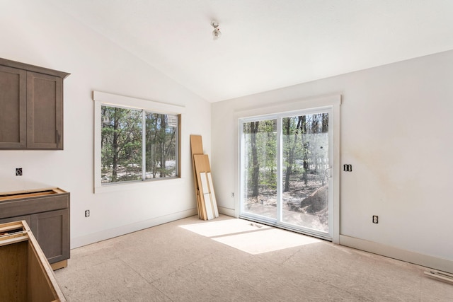 1826 S Barnes Rd, Muskegon, MI 49442 - unfurnished dining area featuring lofted ceiling, plenty of natural light, and light colored carpet