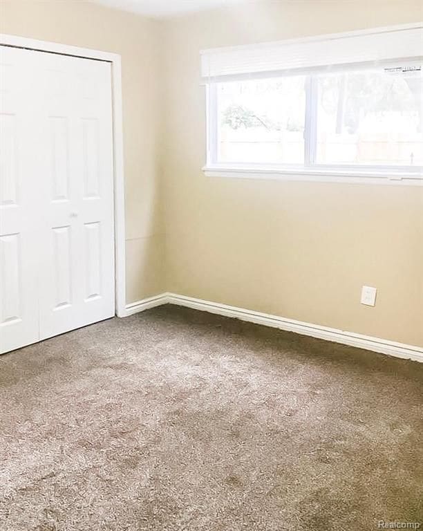 8090 Robson St, Detroit, MI 48228 - carpeted empty room with baseboards