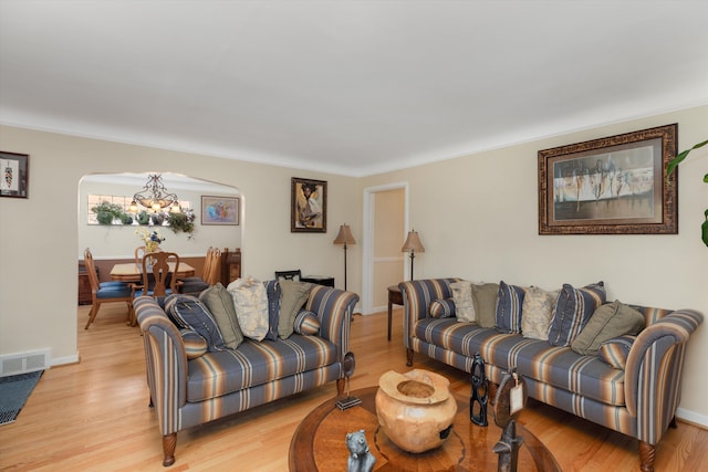 2220 Stanhope St, Grosse Pointe Woods, MI 48236 - living area with arched walkways, a chandelier, light wood-style flooring, baseboards, and ornamental molding