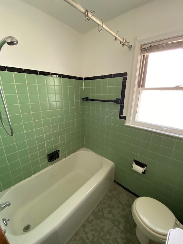 full bath with tile walls, toilet, wainscoting, and tile patterned floors