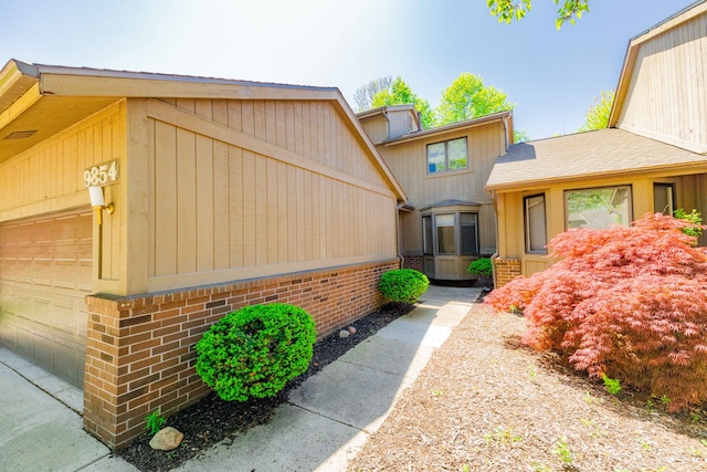 view of front of home featuring brick siding and a garage