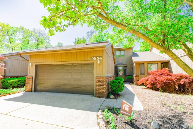view of front of house with brick siding, a garage, and concrete driveway