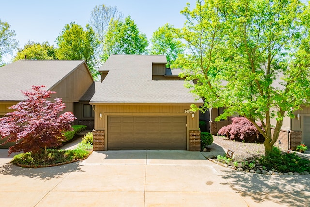 mid-century modern home featuring brick siding, driveway, an attached garage, and roof with shingles