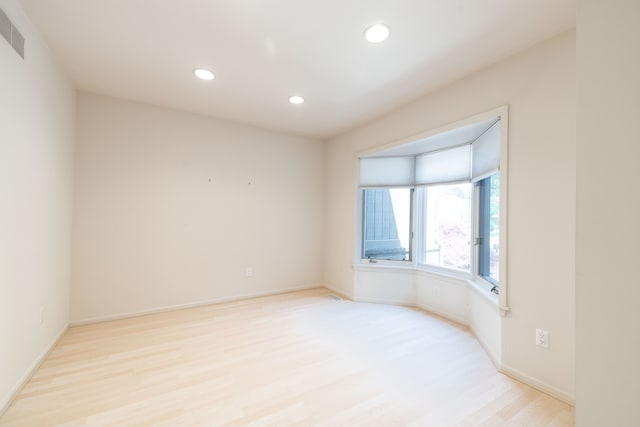 spare room with light wood-type flooring, recessed lighting, and baseboards