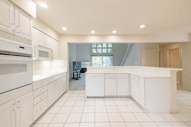 kitchen featuring white appliances, a sink, light countertops, recessed lighting, and white cabinetry