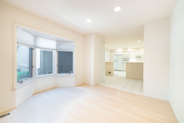 spare room with recessed lighting, light wood-style floors, and baseboards