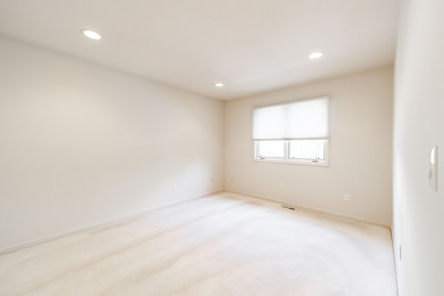 empty room with recessed lighting, light carpet, and baseboards