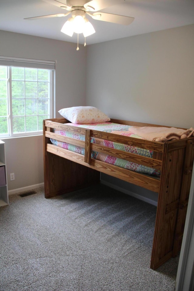 carpeted bedroom with a ceiling fan and baseboards