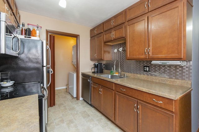 1609 Sheridan Ave, Niles, MI 49120 - kitchen featuring stacked washing machine and dryer, stainless steel appliances, a sink, and tasteful backsplash