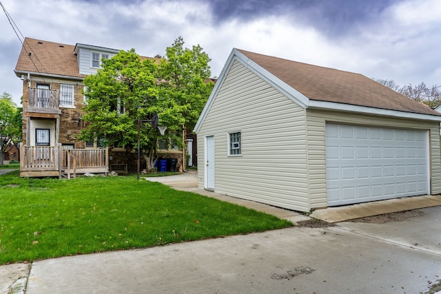 2285 Chicago Blvd, Detroit, MI 48206 - view of side of property featuring an outdoor structure, a detached garage, a lawn, a shingled roof, and a balcony
