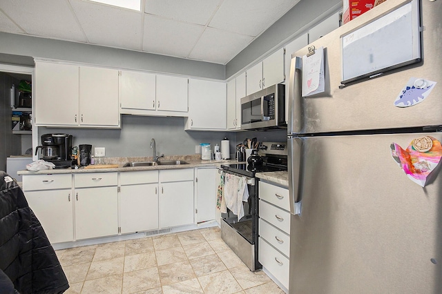 238-240 W Division St, Sparta, MI 49345 - kitchen featuring appliances with stainless steel finishes, a sink, a paneled ceiling, white cabinetry, and light countertops
