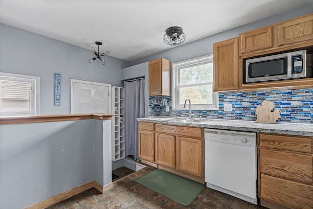 30664 Burlington St, Westland, MI 48186 - kitchen featuring white dishwasher, stainless steel microwave, a sink, tasteful backsplash, and baseboards