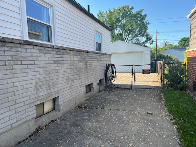 30664 Burlington St, Westland, MI 48186 - view of home's exterior featuring a detached garage, a gate, and an outbuilding