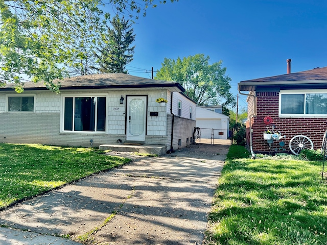 30664 Burlington St, Westland, MI 48186 - view of front facade featuring brick siding, a front lawn, a garage, and an outdoor structure