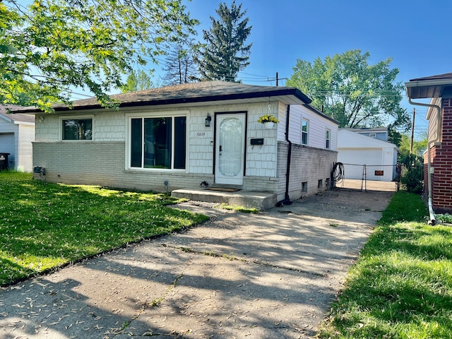 30664 Burlington St, Westland, MI 48186 - view of front of property with brick siding, a gate, a garage, and an outdoor structure