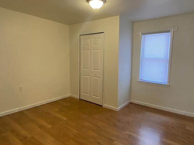 empty room with wood finished floors and baseboards