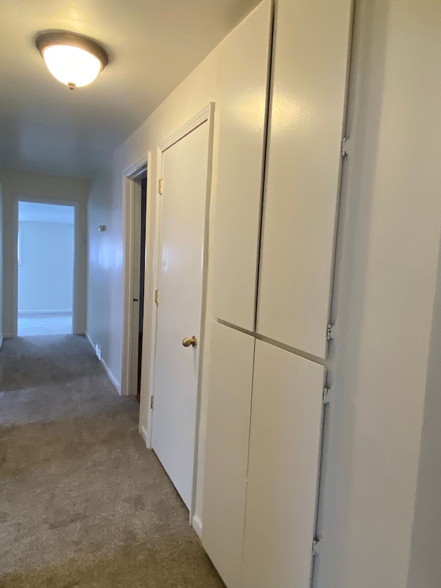 corridor with carpet and baseboards
