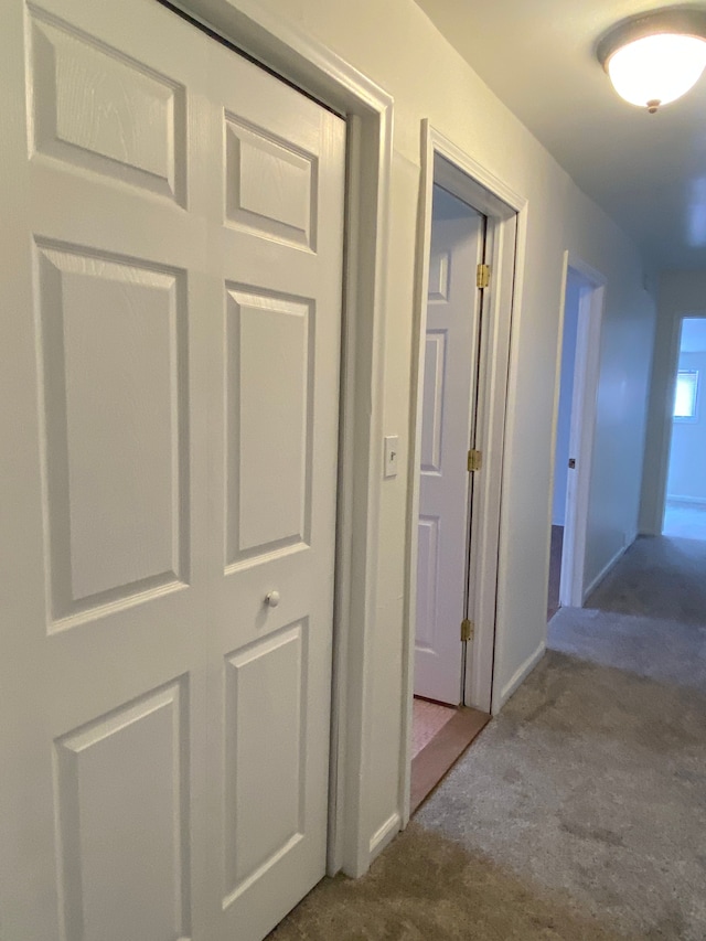 corridor with carpet flooring and baseboards