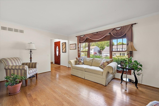 living room with crown molding and light wood finished floors