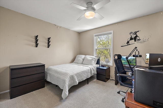 bedroom with light colored carpet, a desk, and a ceiling fan