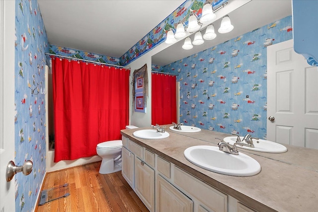 bathroom with wallpapered walls, wood finished floors, double vanity, toilet, and shower / bath combo with shower curtain