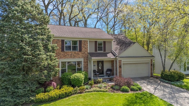 traditional-style house featuring an attached garage, brick siding, concrete driveway, a front yard, and a chimney