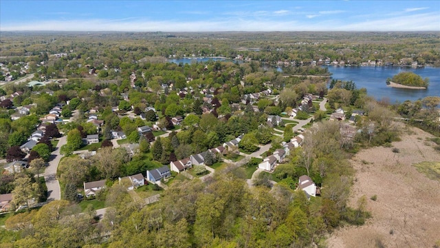 view of property location with a nearby body of water and a heavily wooded area