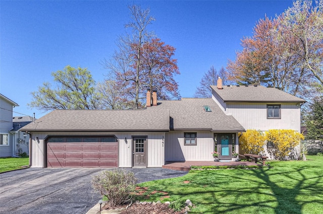 3541 Highland Blvd, Highland, MI 48356 - view of front of house with a garage, driveway, a chimney, a front lawn, and a shingled roof