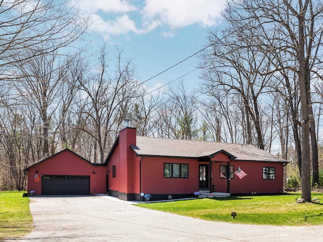 119 Maple St, Fife Lake, MI 49633 - view of front of property with a garage, concrete driveway, a chimney, and a front yard