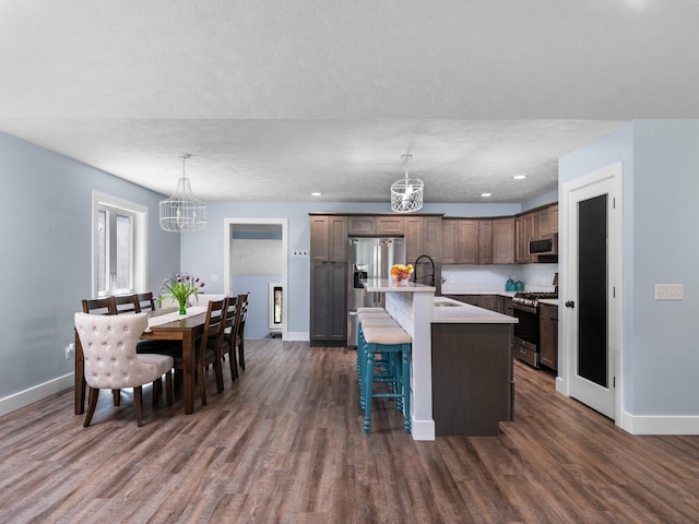 119 Maple St, Fife Lake, MI 49633 - kitchen featuring stainless steel appliances, a chandelier, a sink, baseboards, and a breakfast bar