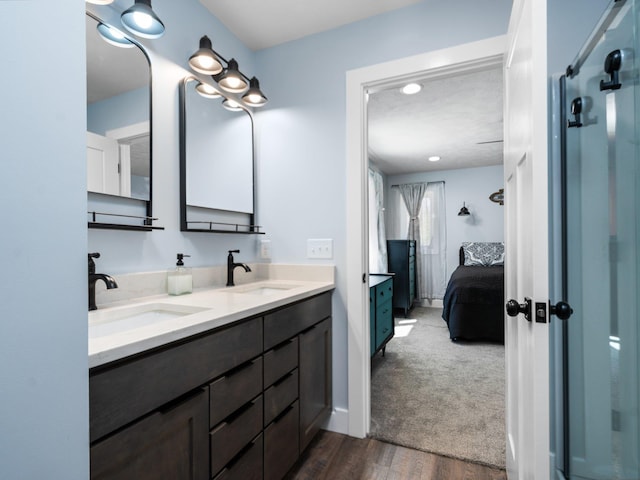 119 Maple St, Fife Lake, MI 49633 - full bath featuring double vanity, connected bathroom, a shower with door, and wood finished floors