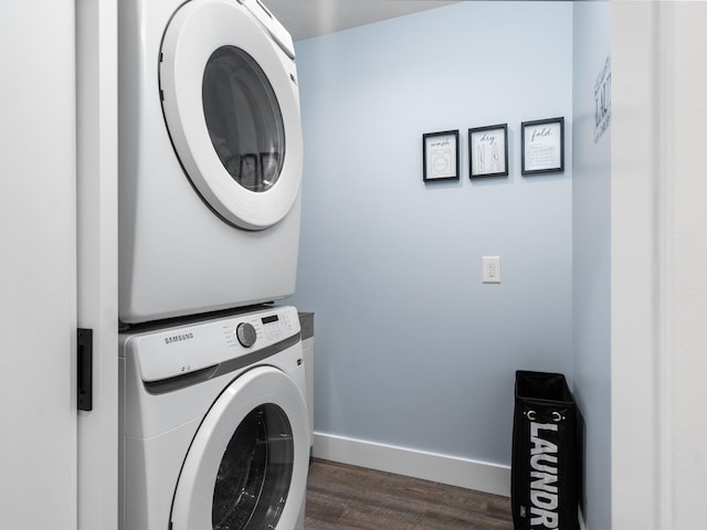 119 Maple St, Fife Lake, MI 49633 - clothes washing area with stacked washer / dryer, dark wood-style floors, and baseboards