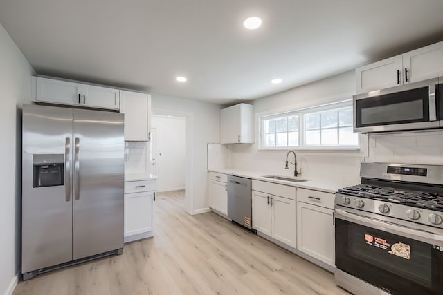 8345 Pontiac Lake Rd, White Lake, MI 48386 - kitchen featuring appliances with stainless steel finishes, a sink, tasteful backsplash, white cabinetry, and recessed lighting