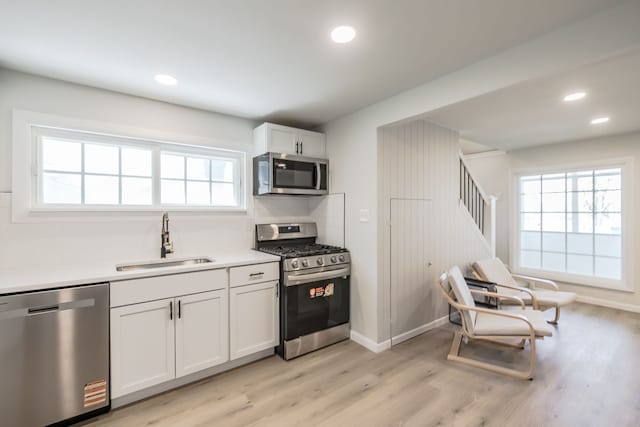 8345 Pontiac Lake Rd, White Lake, MI 48386 - kitchen with stainless steel appliances, a sink, plenty of natural light, light wood-style floors, and recessed lighting