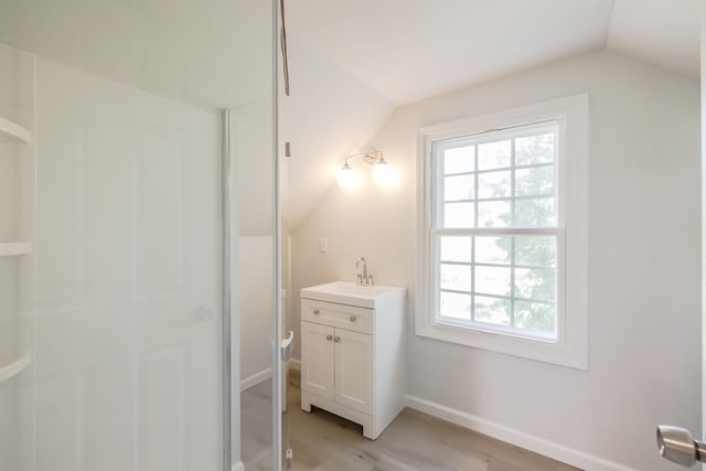 8345 Pontiac Lake Rd, White Lake, MI 48386 - bathroom with lofted ceiling, plenty of natural light, wood finished floors, baseboards, and vanity