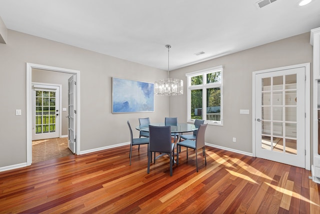 dining area with wood finished floors, baseboards, and a chandelier