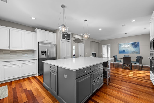 kitchen with gray cabinets, appliances with stainless steel finishes, white cabinets, light countertops, and light wood-type flooring