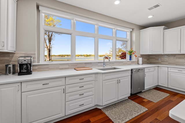 kitchen with a sink, stainless steel dishwasher, white cabinetry, tasteful backsplash, and recessed lighting