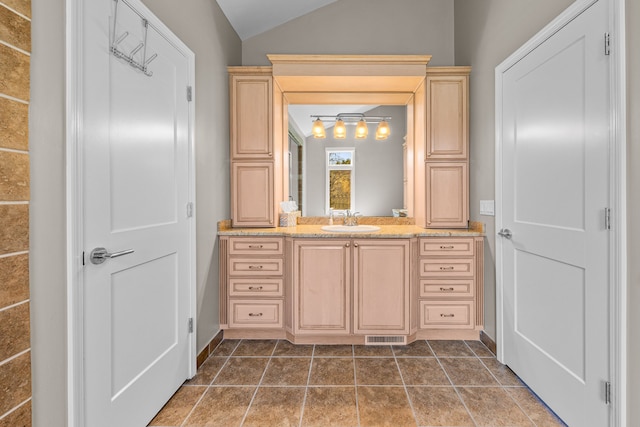 bathroom featuring lofted ceiling, vanity, and baseboards