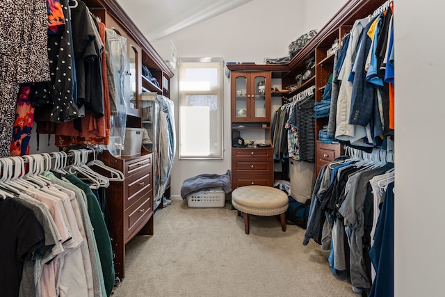 walk in closet featuring light colored carpet and vaulted ceiling