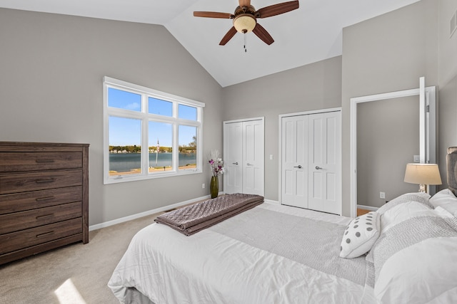 bedroom featuring high vaulted ceiling, carpet, multiple closets, baseboards, and ceiling fan