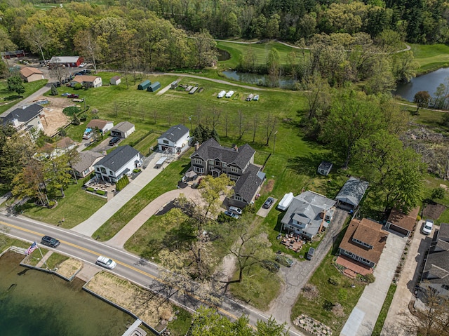 aerial view of property and surrounding area featuring a large body of water and nearby suburban area