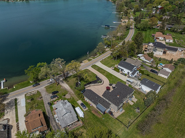 aerial view of property and surrounding area featuring a large body of water and nearby suburban area
