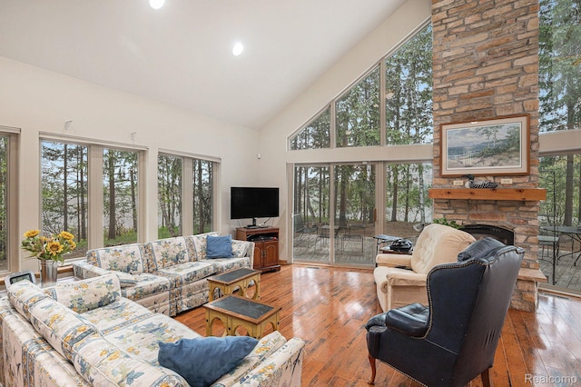 5793 Gark Rd, Attica, MI 48412 - living room with high vaulted ceiling, hardwood / wood-style flooring, a stone fireplace, and recessed lighting