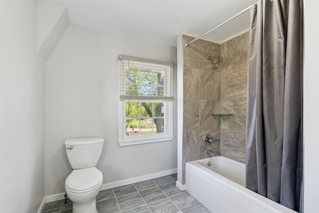 bathroom with toilet, shower / tub combo, and baseboards