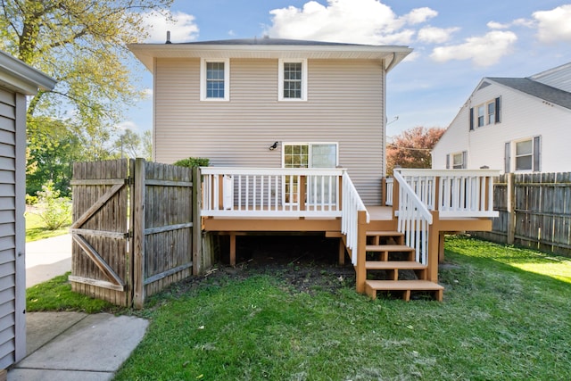 rear view of house featuring a wooden deck and a gate