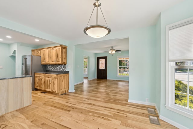 kitchen featuring high end fridge, light wood-style flooring, decorative backsplash, baseboards, and recessed lighting